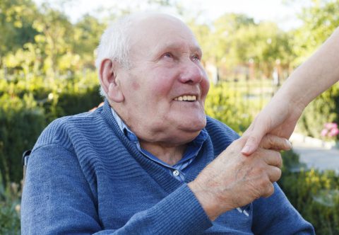 Elderly man holding a hand