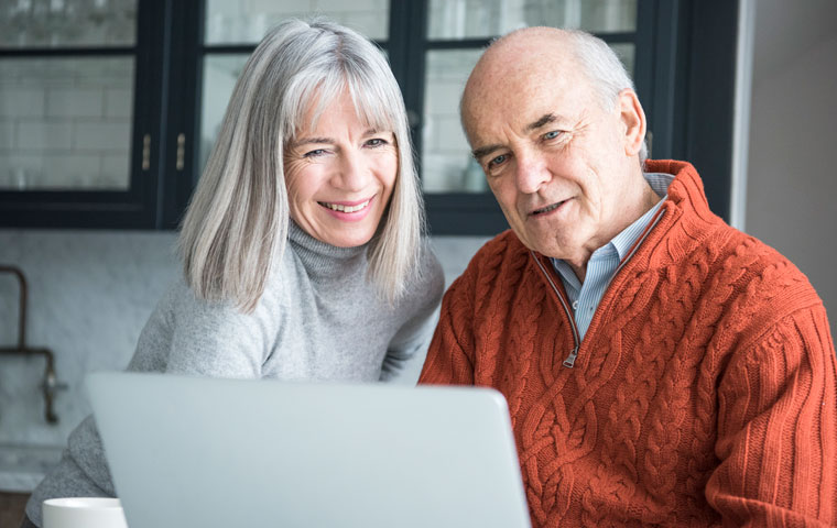 Couple looking at computer as they learn about elder care technology.