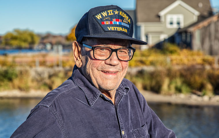 An elderly veteran smiles. Home health care for veterans has helped make his life easier at home.