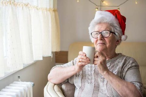senior-woman-sitting-drinking-coffee-santa-hat
