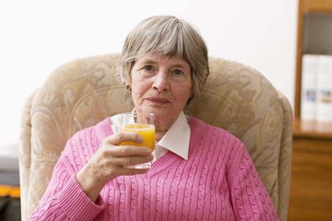 woman-sitting-drinking-orange-juice