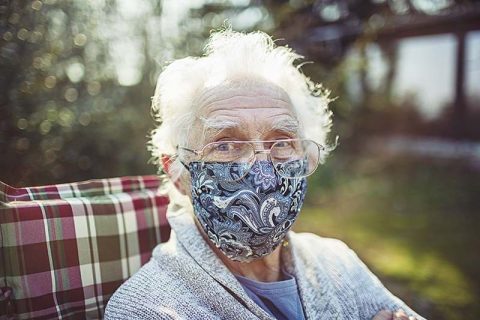 senior-woman-sitting-outside-with-mask