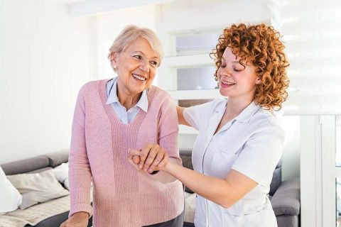 happy-senior-woman-getting-assistance-from-caregiver