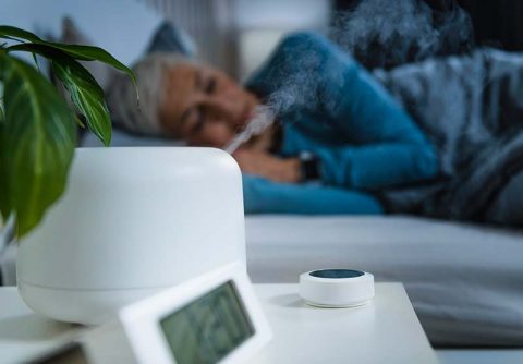 A woman sleeps while using a humidifier in her room after reading up on information about air quality and COPD.