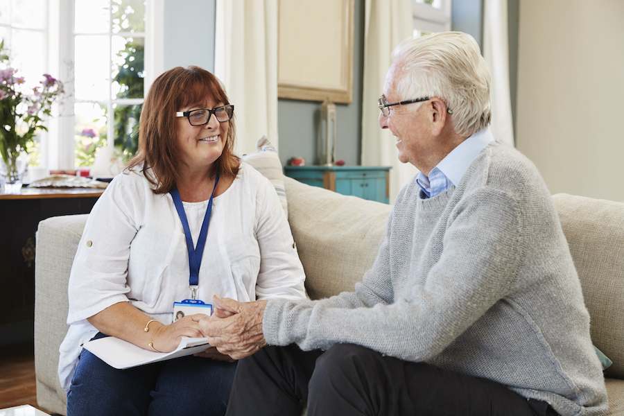 A caregiver discusses senior home care services with an elderly client.
