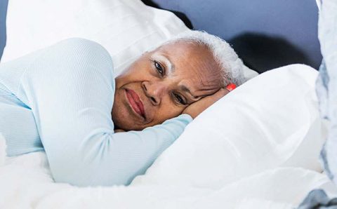 senior-woman-laying-in-bed