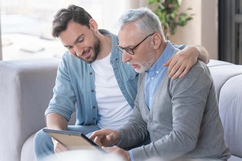 adult-son-with-senior-father-looking-at-picture