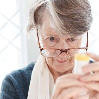 senior lady reading medicine bottle