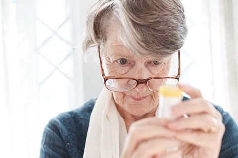 senior lady reading medicine bottle