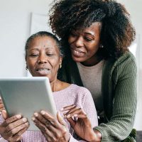 senior lady and caregiver looking at tablet