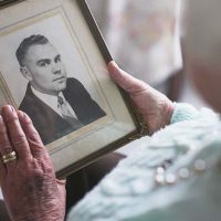 senior lady holding old photo dealing with broken heart syndrome