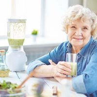 happy senior lady drinking a smoothie