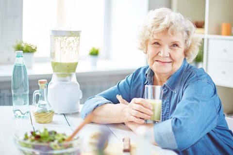 happy senior lady drinking a smoothie