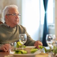 senior-man-sitting-at-dinner-table