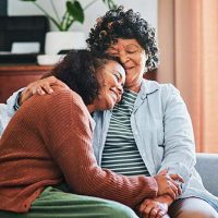 daughter hugging and caring for senior mother