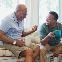 The adult child of a senior with dementia responds to conversation loops as they talk over coffee.