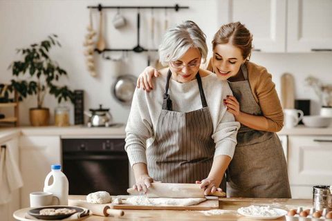 The adult child of a senior practices dementia care cooking tips for seniors.