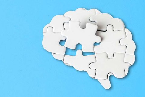 A brain made of puzzle pieces is missing a piece in the middle.